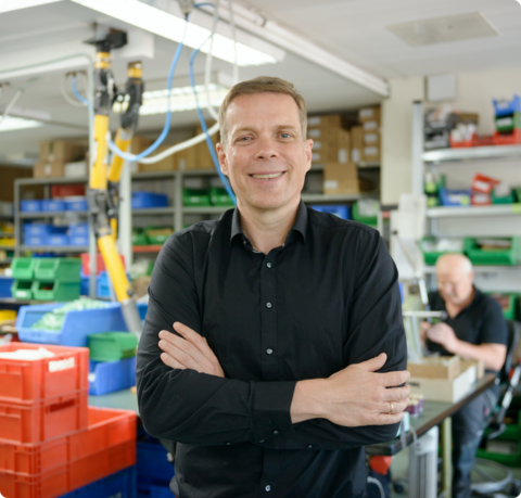 Rolf Treusch ist stolz auf die Arbeit des Rotek-Teams und auf die innovativen Elektro-Kleinmotoren | © Antje Schimanke/Gedankenwerft Mann lächelt mit verschränkten Armen in die Kamera | © Antje Schimanke/Gedankenwerft