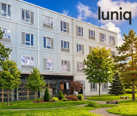 Das Gebäude luniq von außen umgeben von vielen Bäumen und Gräsern | © BIS / KI-generiert