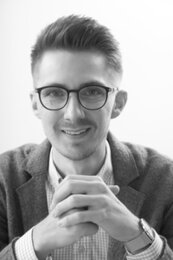 Dennis Spörhase | © BIS/Jens Meier Portrait eines Mannes mit Brille, der seine Hände gefaltet hat und in die Kamera lächelt | © BIS/Jens Meier